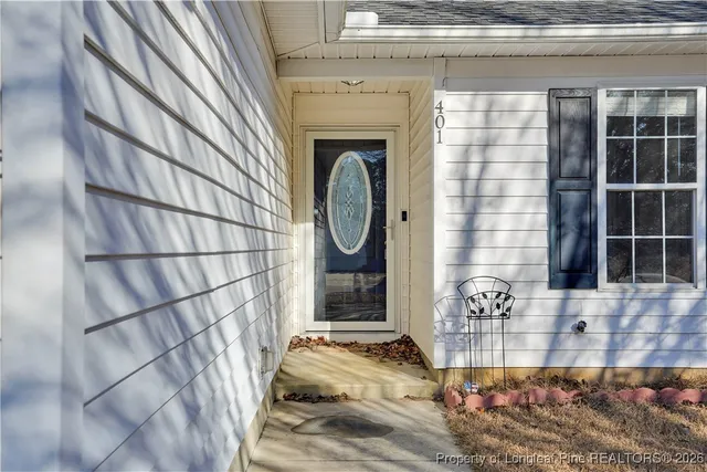 an empty room with windows fireplace and wooden floor