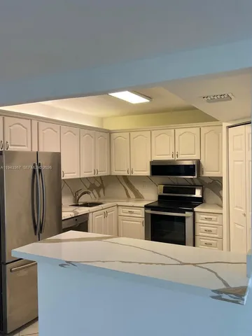 a kitchen with stainless steel appliances a stove microwave and refrigerator