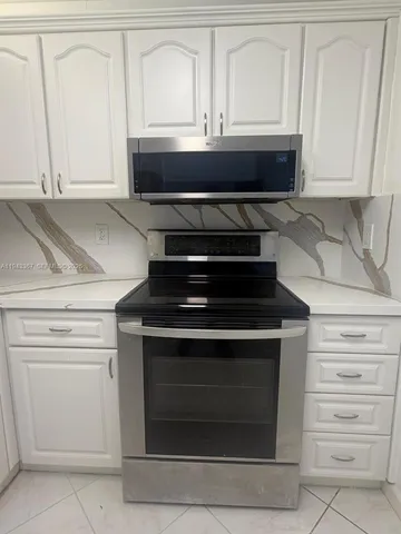 a stove top oven sitting inside of a kitchen