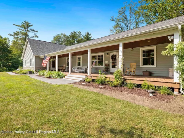 a view of a house with backyard sitting area and swimming pool