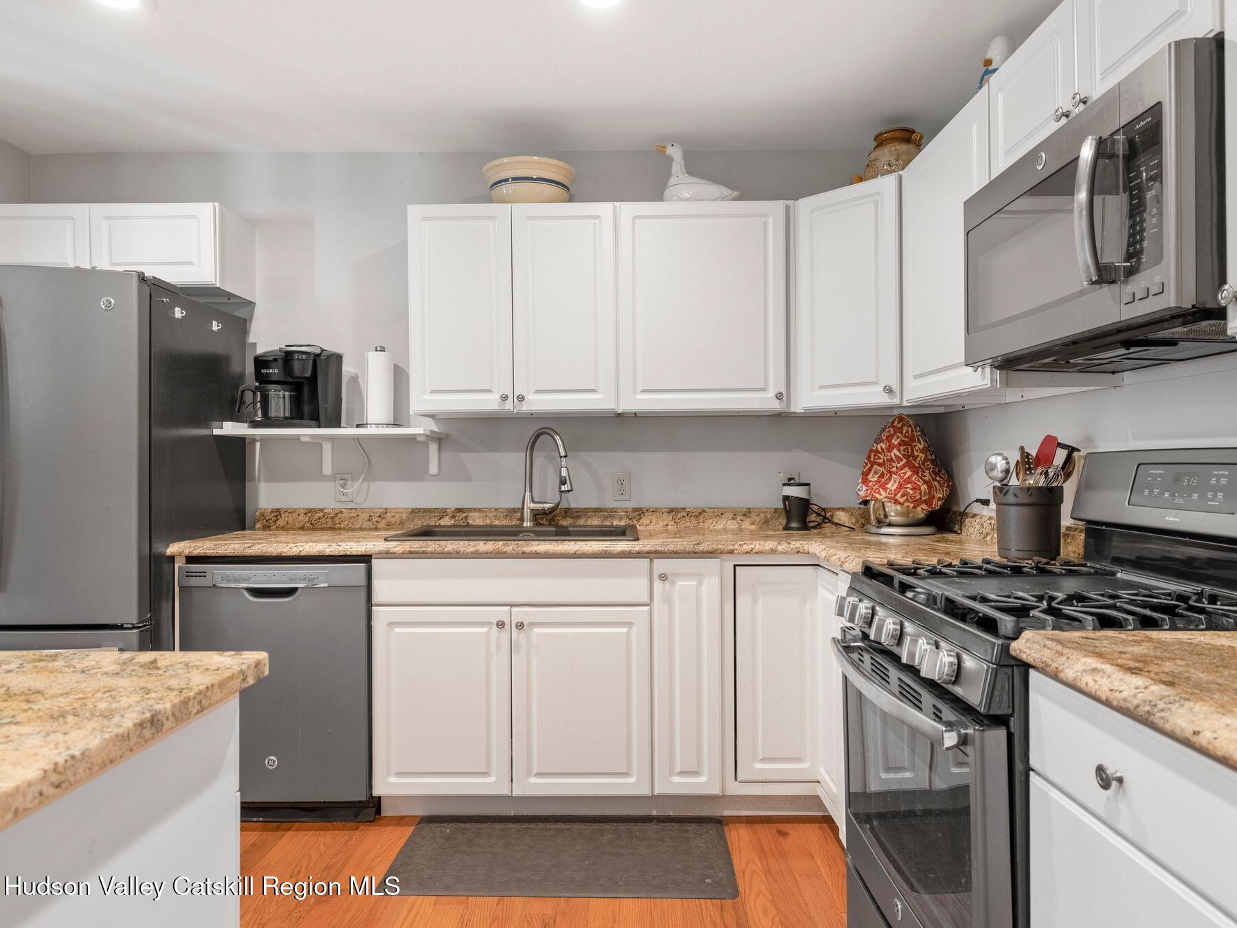 15 Pine Street Cairo, NY 12413 - Photo 36 of 46 a kitchen with stainless steel appliances granite countertop a stove top oven a refrigerator a sink and dishwasher with white cabinets