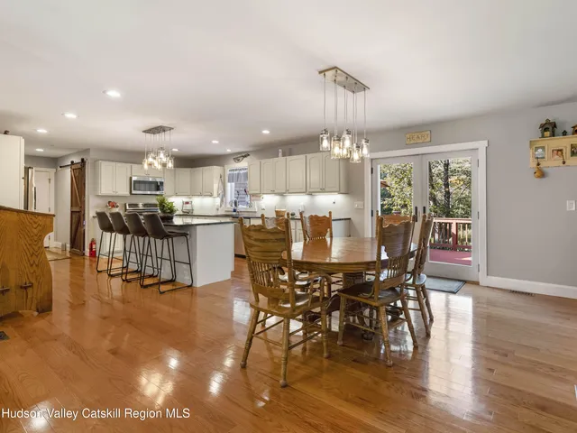 a view of a dining room with furniture a chandelier and wooden floor