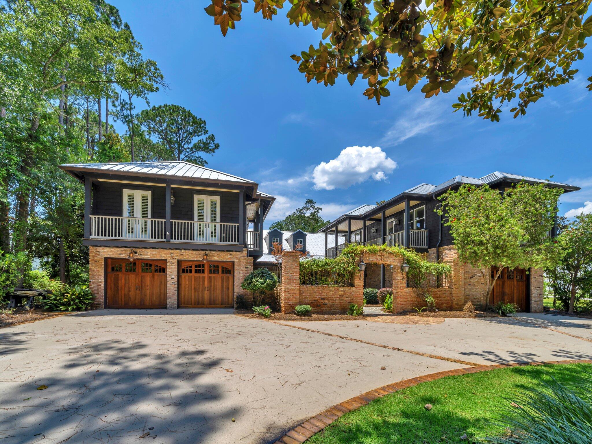 389 Driftwood Point Road Santa Rosa Beach, FL 32459 - Photo 7 of 79 a front view of a house with a yard and garage