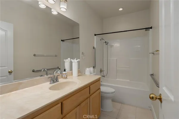 a bathroom with a shower sink vanity mirror and toilet