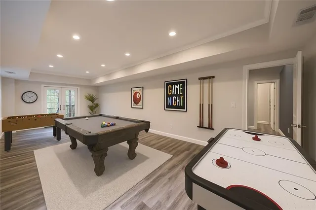 a room with furniture pool table and wooden floor
