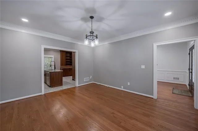 a view of a room with wooden floor staircase and a kitchen