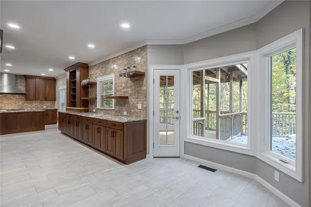 a large kitchen with stainless steel appliances granite countertop a large counter top and a large window