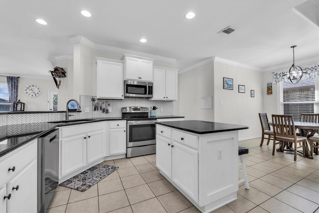 9453 Centennial Drive Waco, TX 76708 - Photo 24 of 37 a kitchen with granite countertop white cabinets and appliances