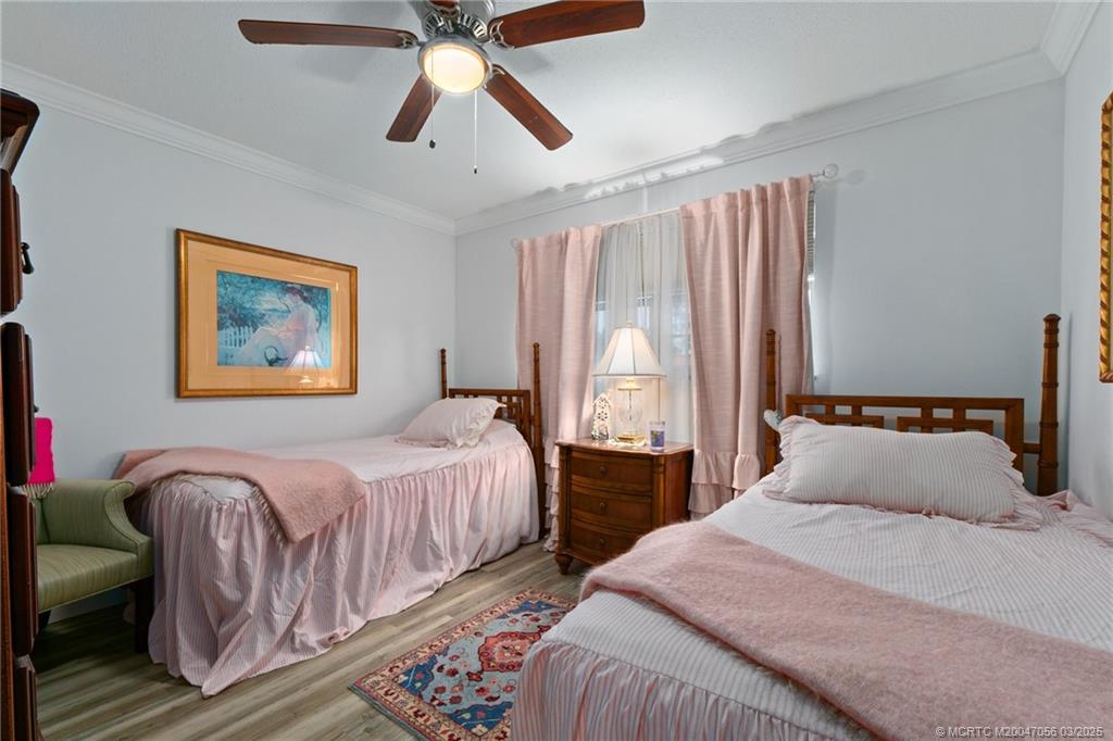 1985 Southwest Palm City Road, Unit 44I Stuart, FL 34994 - Photo 20 of 31 a bedroom with beds and a chandelier