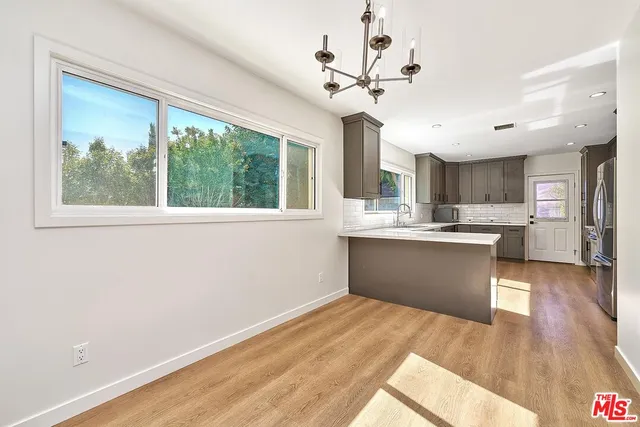 a kitchen with stainless steel appliances granite countertop a refrigerator a stove and a sink