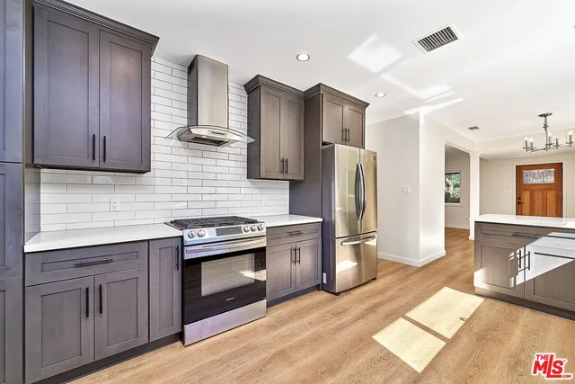 a kitchen with stainless steel appliances a refrigerator sink and cabinets