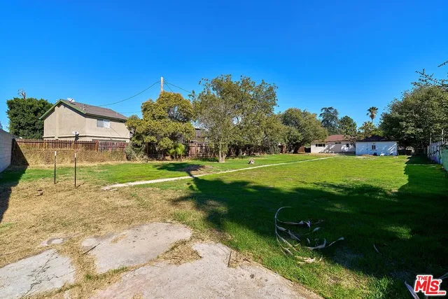 a view of a house with a tree in the backyard