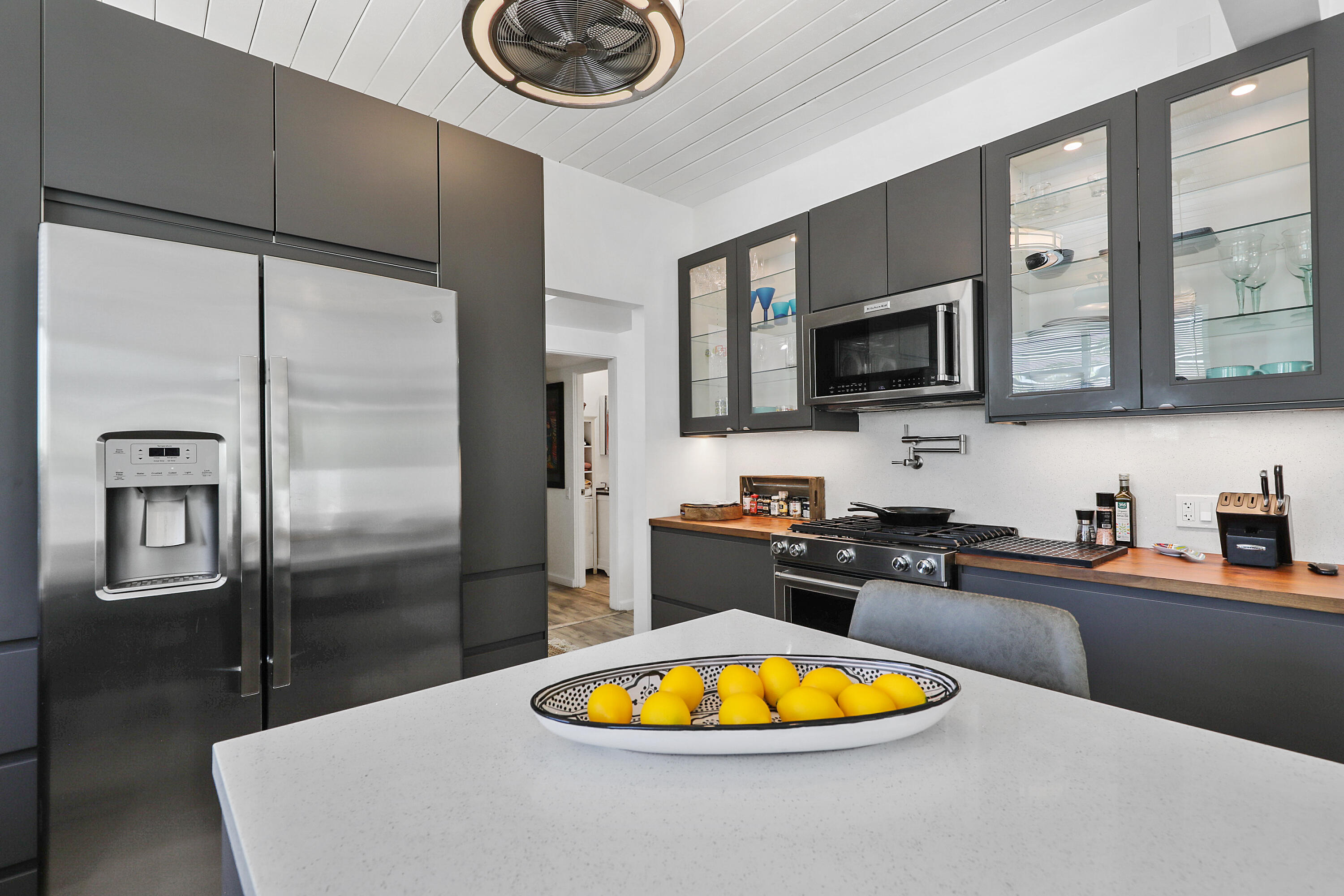 71333 Halgar Road Rancho Mirage, CA 92270 - Photo 11 of 33 a kitchen with stainless steel appliances granite countertop a refrigerator a stove a sink and a dining table with wooden floor