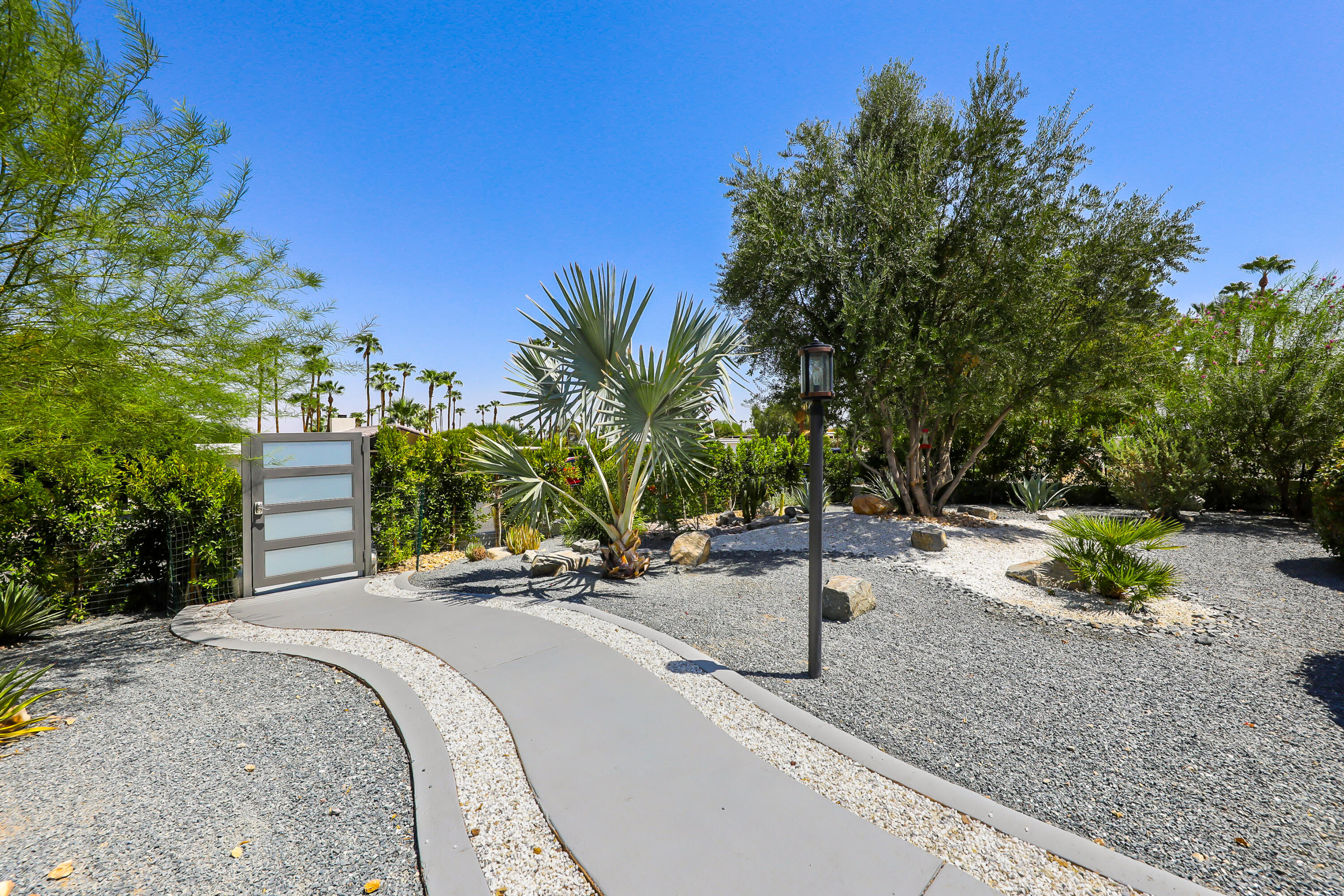 71333 Halgar Road Rancho Mirage, CA 92270 - Photo 3 of 33 a view of a park with potted plants and large trees