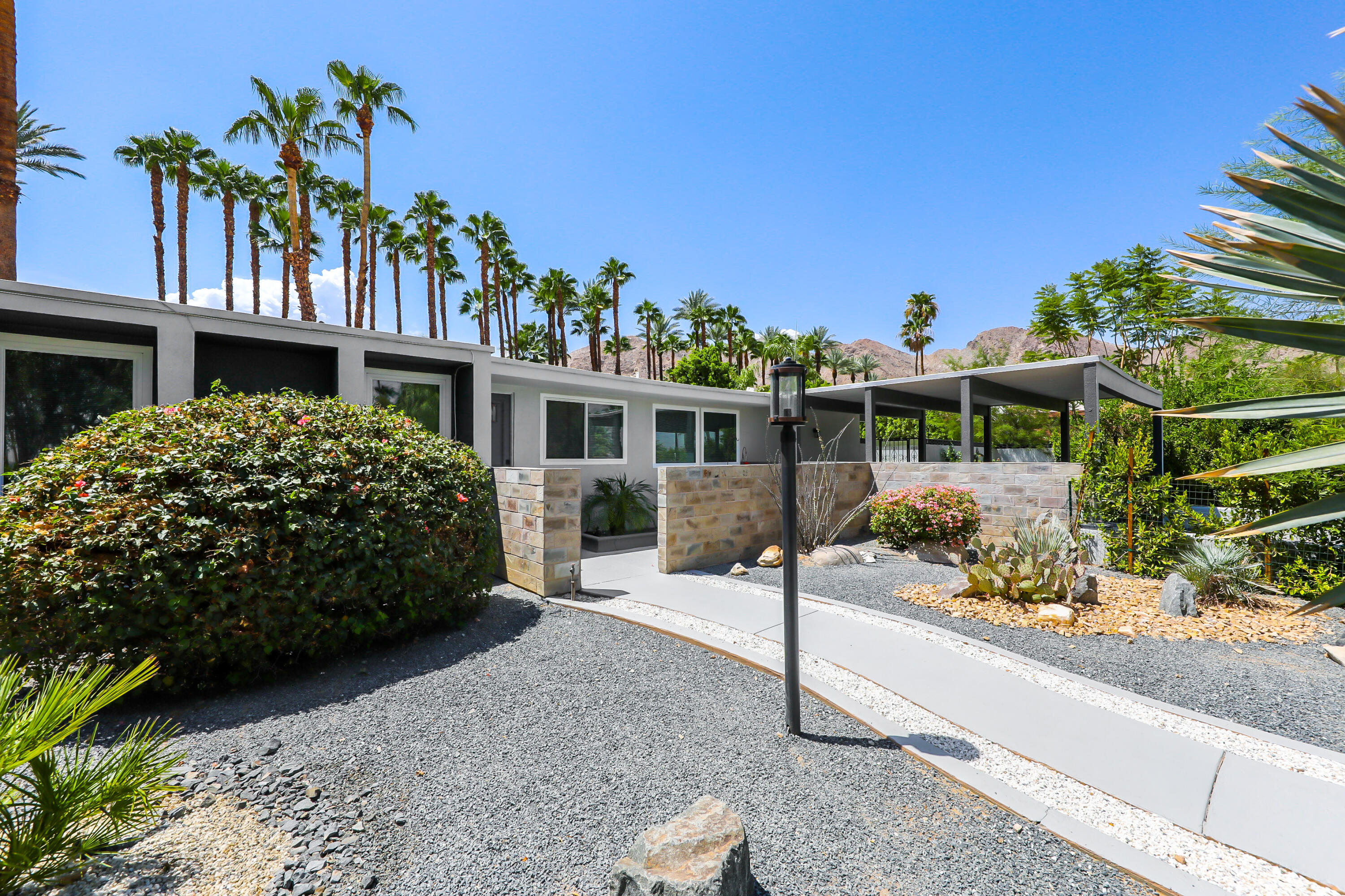 71333 Halgar Road Rancho Mirage, CA 92270 - Photo 32 of 33 a front view of a house with a yard and potted plants