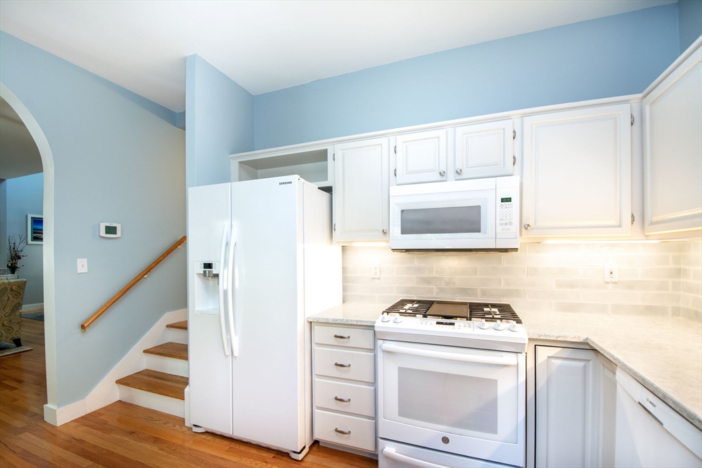 1 Gatehouse Lane, Unit 1 Hull, MA 02045 - Photo 7 of 42 a kitchen with white cabinets and white appliances