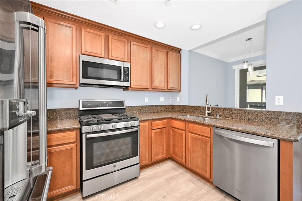 22 Valmont Way Ladera Ranch, CA 92694 - Photo 13 of 47 a kitchen with stainless steel appliances granite countertop a stove microwave and sink