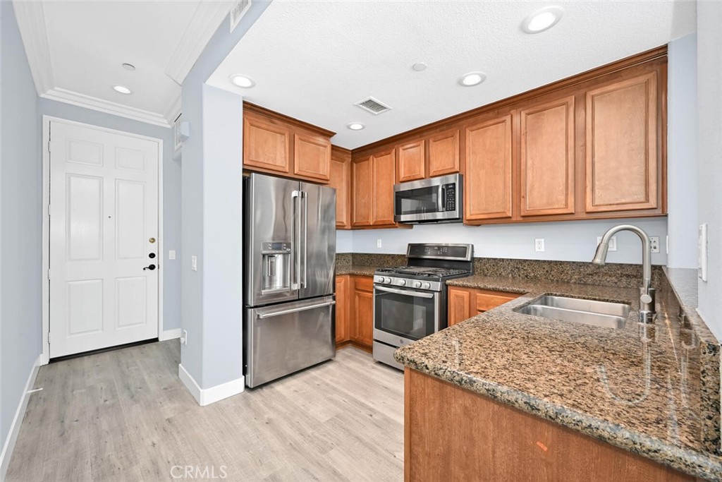 22 Valmont Way Ladera Ranch, CA 92694 - Photo 14 of 47 a kitchen with stainless steel appliances granite countertop a stove top oven a refrigerator and a sink with granite countertops