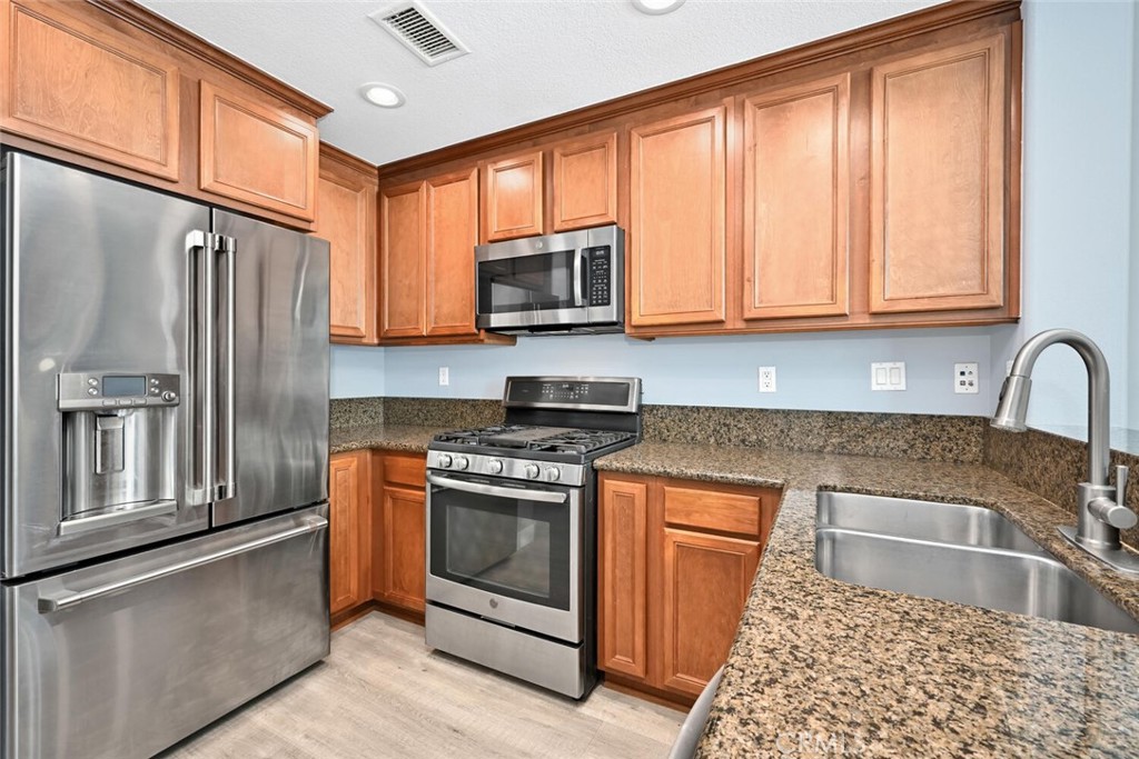 22 Valmont Way Ladera Ranch, CA 92694 - Photo 15 of 47 a kitchen with granite countertop wooden cabinets stainless steel appliances and a window