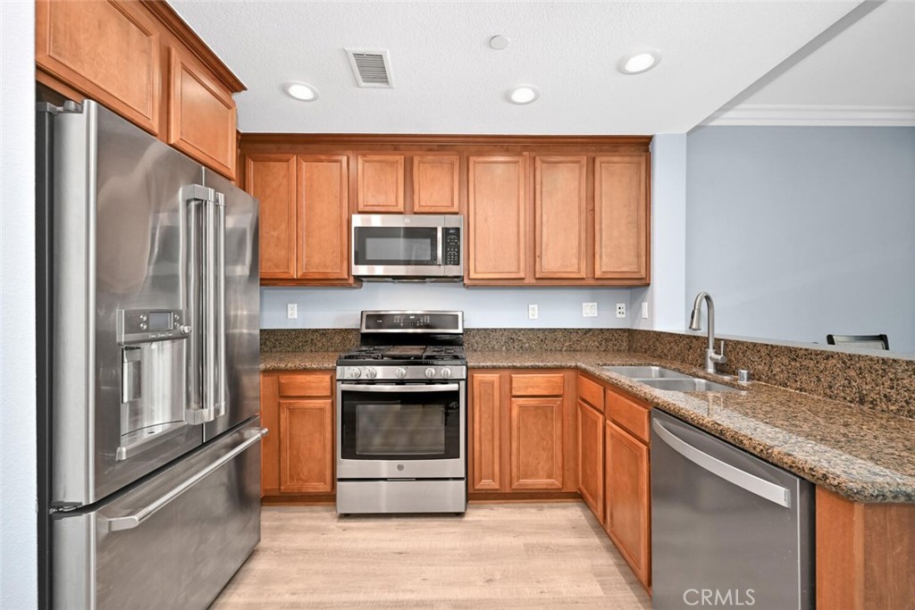 22 Valmont Way Ladera Ranch, CA 92694 - Photo 10 of 47 a kitchen with stainless steel appliances granite countertop a stove top oven a sink and dishwasher