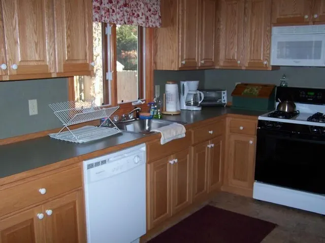 a kitchen with granite countertop a sink a stove and cabinets