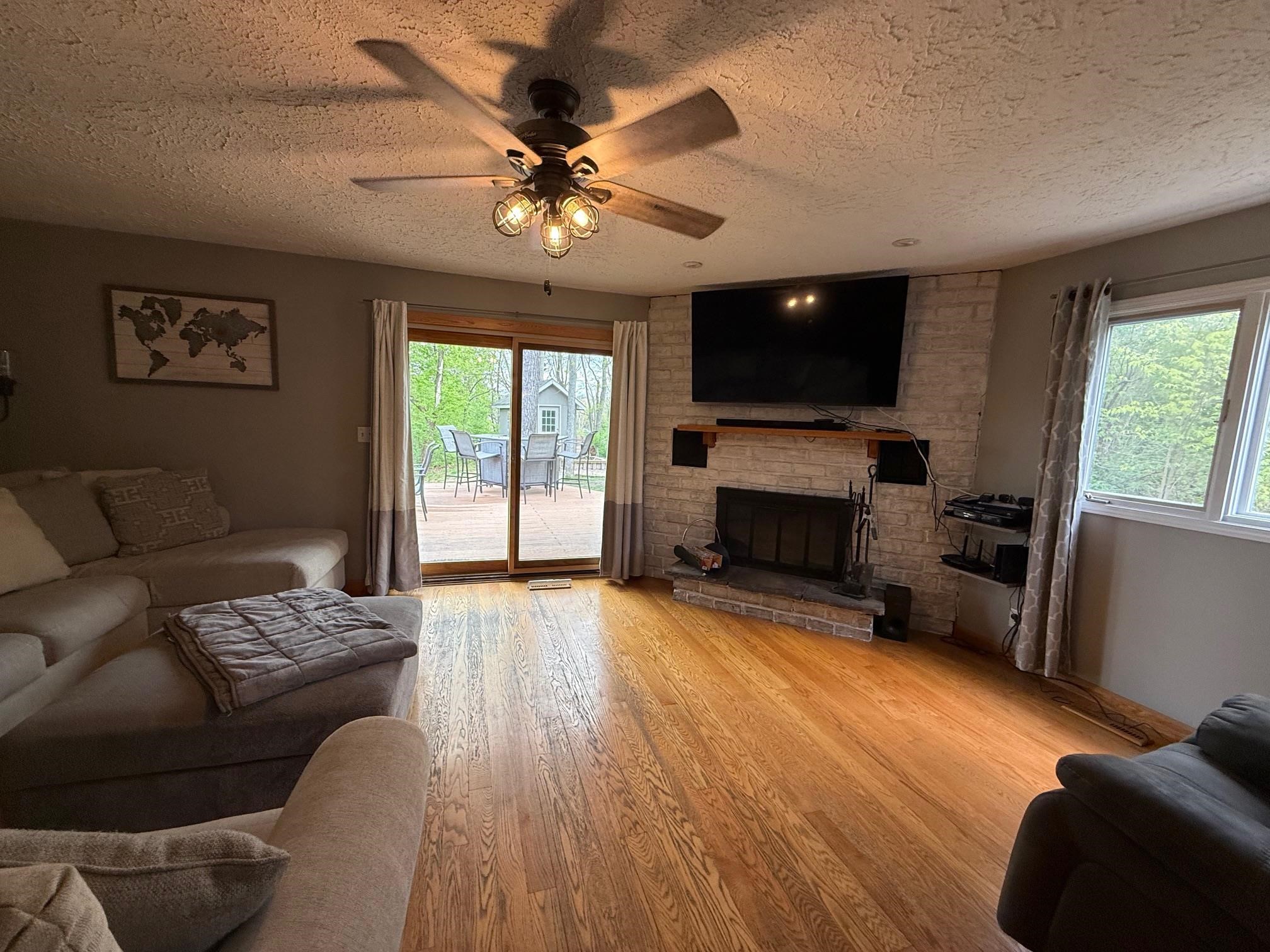 7758 Ray Court Roscoe, IL 61073 - Photo 9 of 37 a living room with furniture a flat screen tv and a fireplace