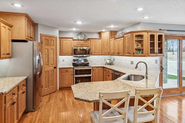 a kitchen with stainless steel appliances granite countertop a kitchen island hardwood floor sink stove and granite counter top