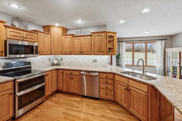 a kitchen with stainless steel appliances granite countertop a stove sink and cabinets
