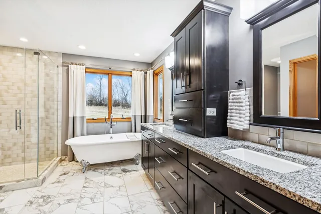 a spacious bathroom with a granite countertop tub sink and mirror