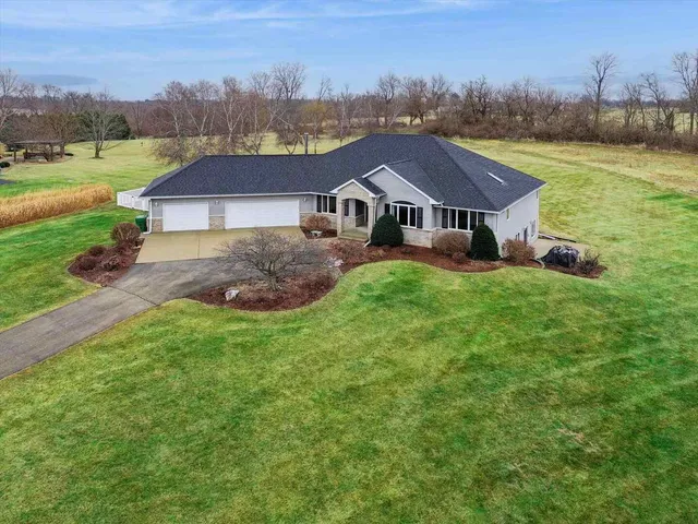 an aerial view of a house with garden space and trees all around