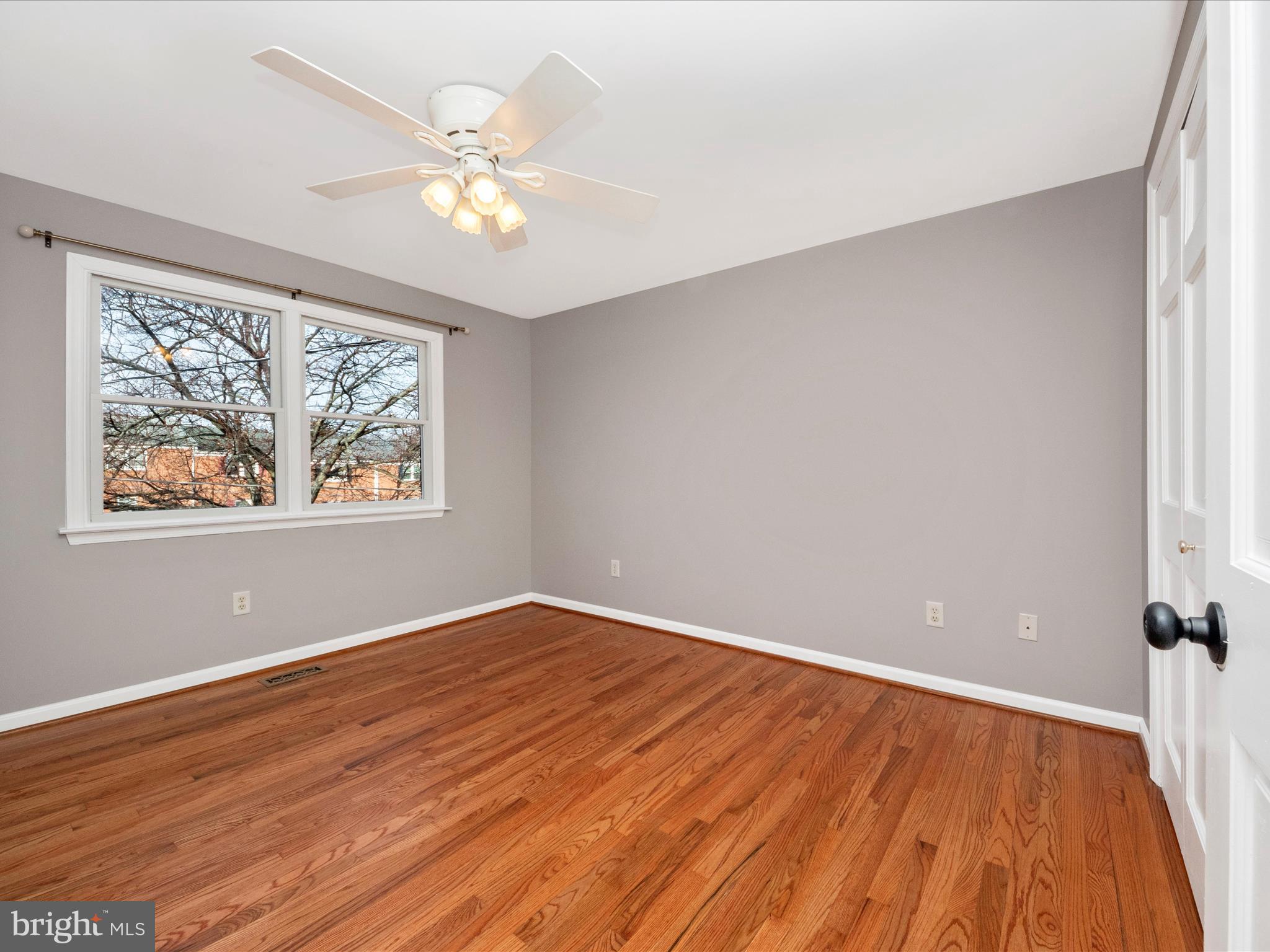 5610 Braxfield Road Halethorpe, MD 21227 - Photo 14 of 32 an empty room with wooden floor chandelier fan and windows