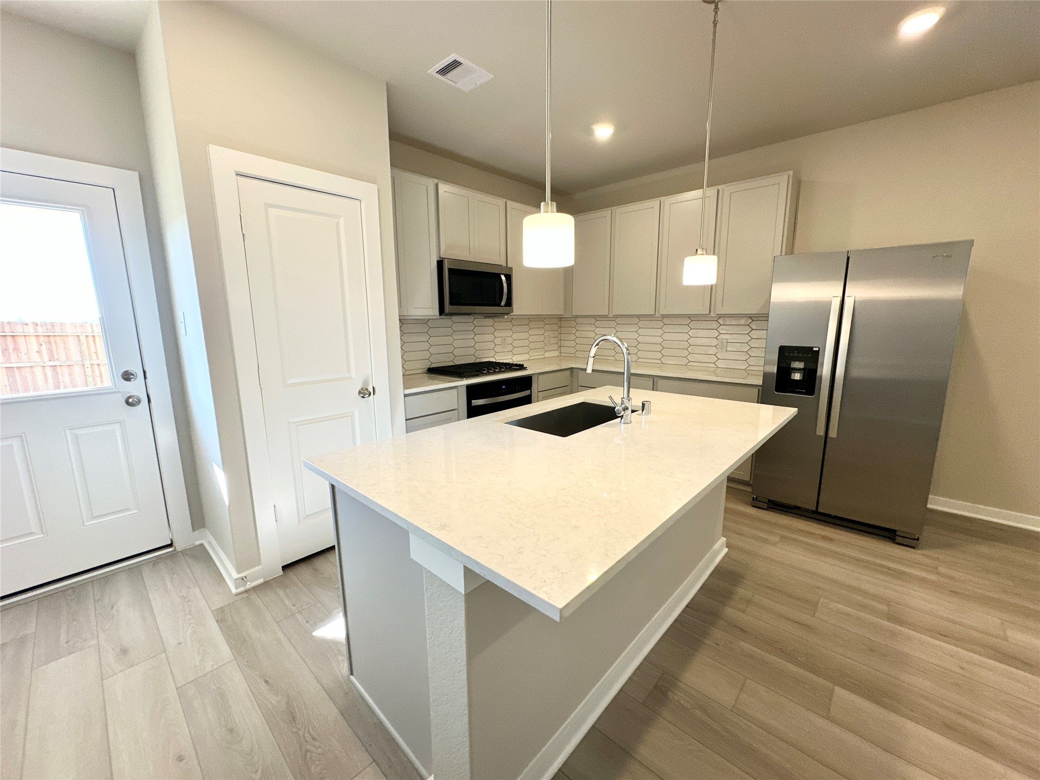 12194 Ridge Top Drive Conroe, TX 77304 - Photo 13 of 33 a kitchen with kitchen island a counter top space a sink a refrigerator and wooden floor