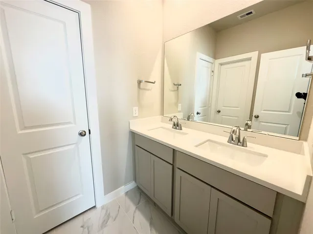 a bathroom with a double vanity sink and mirror