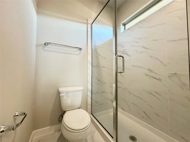 a bathroom with a toilet and a shower