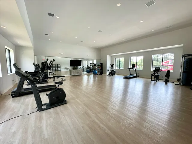 a living room with furniture gym equipment and a view of kitchen