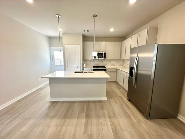 a large kitchen with kitchen island a sink stainless steel appliances and cabinets