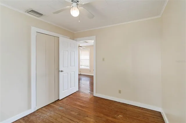 a view of an empty room with wooden floor
