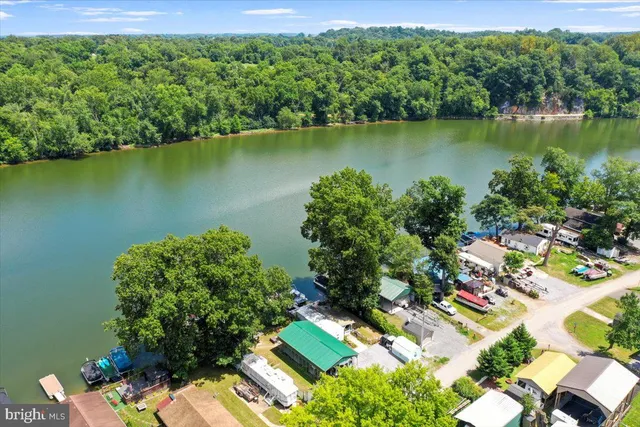 an aerial view of a residential houses with outdoor space and lake view