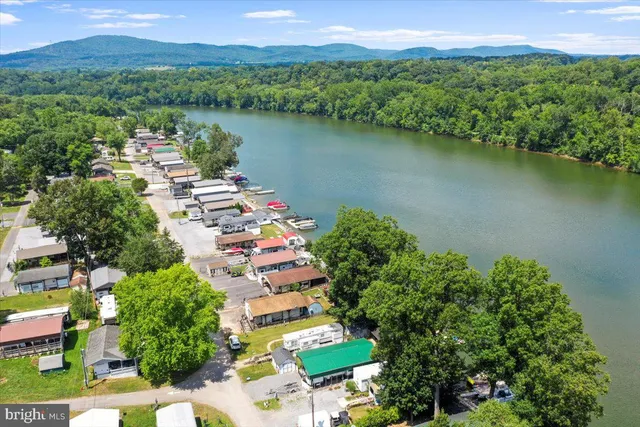 an aerial view of a house with a garden and lake view