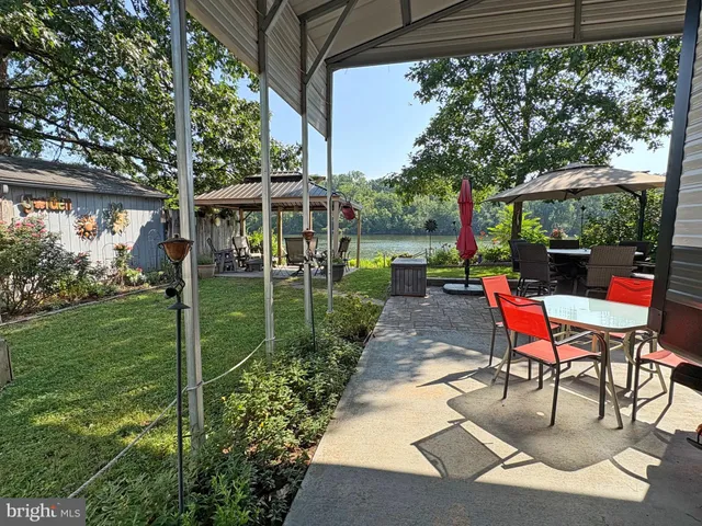 a backyard view with a garden and outdoor seating