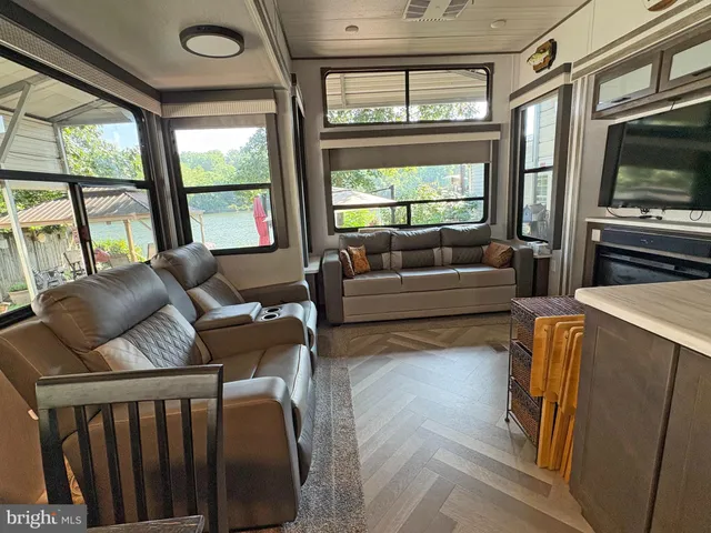 a living room with furniture a flat screen tv and a floor to ceiling window