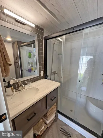 a bathroom with a granite countertop shower and a toilet