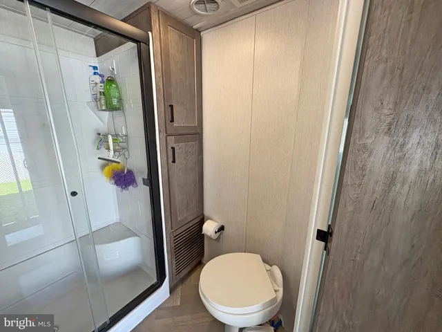 a bathroom with a sink a toilet a mirror and shower