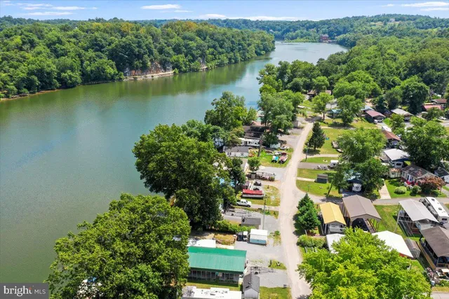 an aerial view of residential houses with outdoor space and trees
