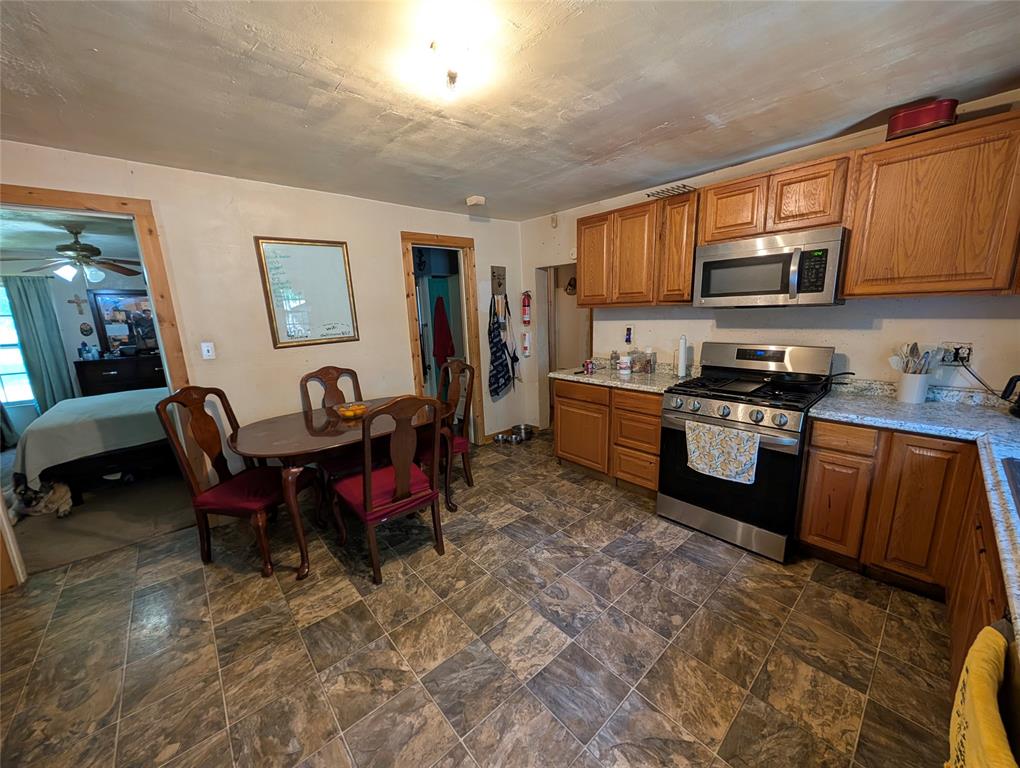 308 Short Street Mansfield, TX 76063 - Photo 9 of 21 a kitchen with granite countertop a sink dishwasher a stove a refrigerator cabinets and a dining table with wooden floor