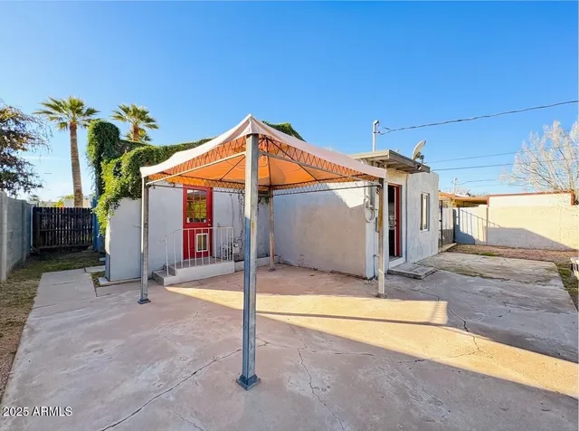 a patio with a table and chairs under an umbrella