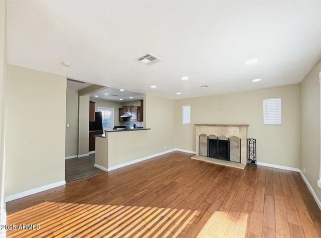 a view of empty room with wooden floor and fireplace