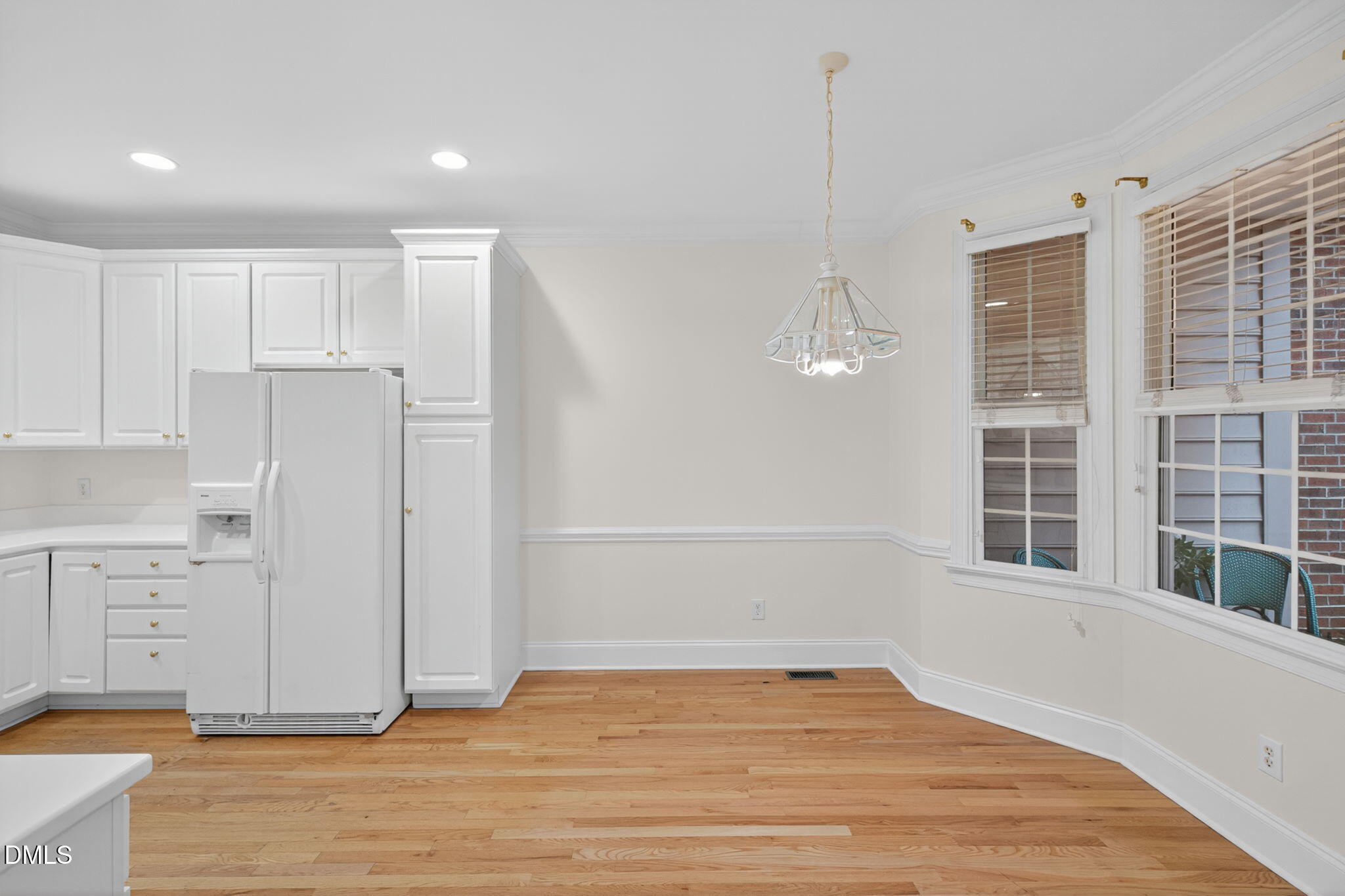 3421 Barron Berkeley Way Raleigh, NC 27612 - Photo 13 of 48 a view of a kitchen with white cabinets and wooden floor