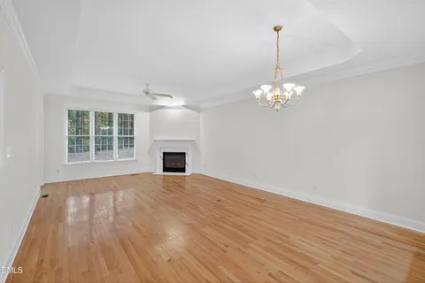 wooden floor fireplace and windows in an empty room