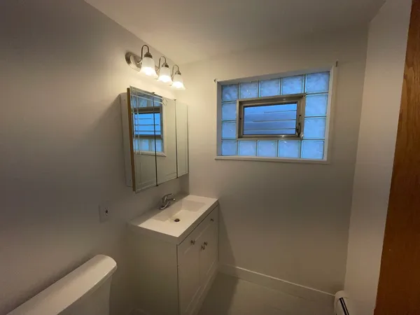 a bathroom with a toilet sink and mirror
